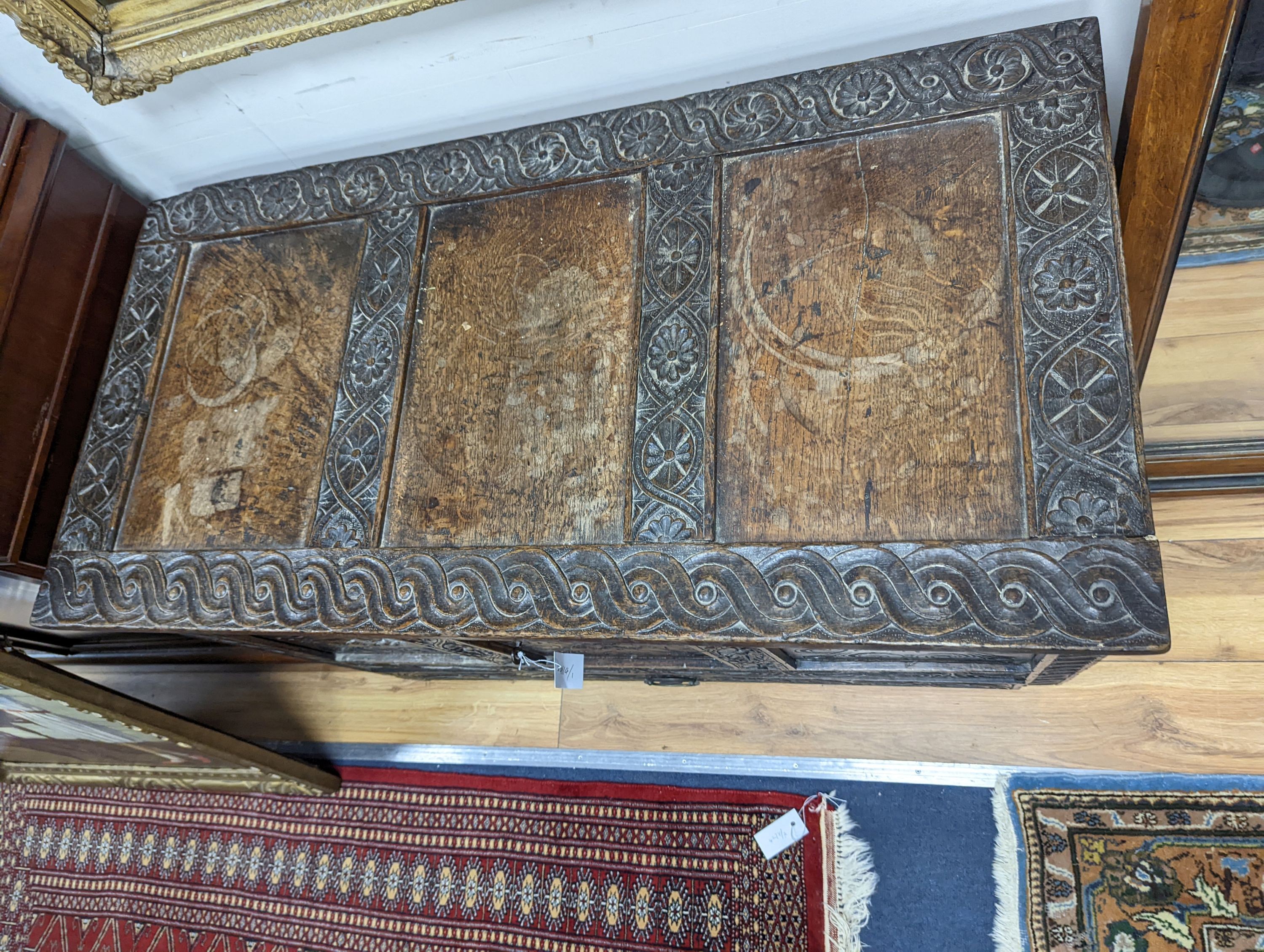 An 18th century oak mule chest with later carved decoration, length 103cm, depth 53cm, height 66cm